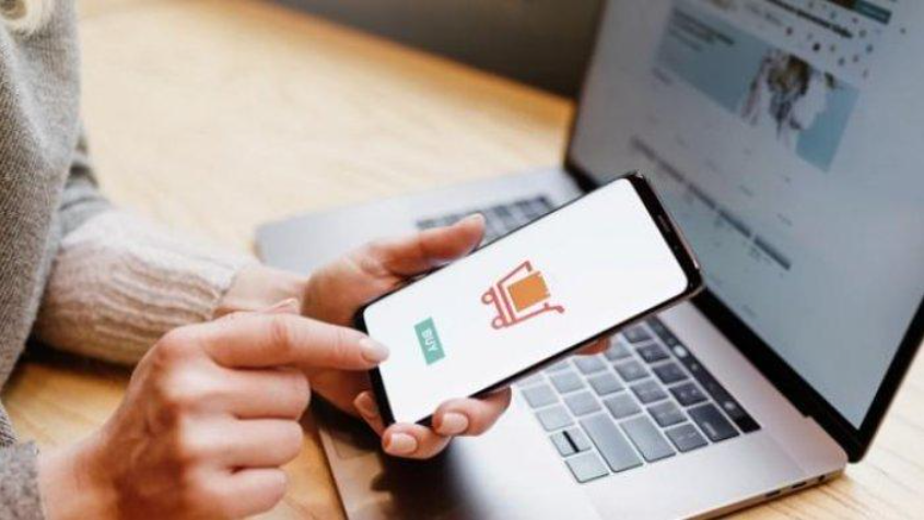 Orang membuka aplikasi marketplace online melalui laptop dan smartphone.